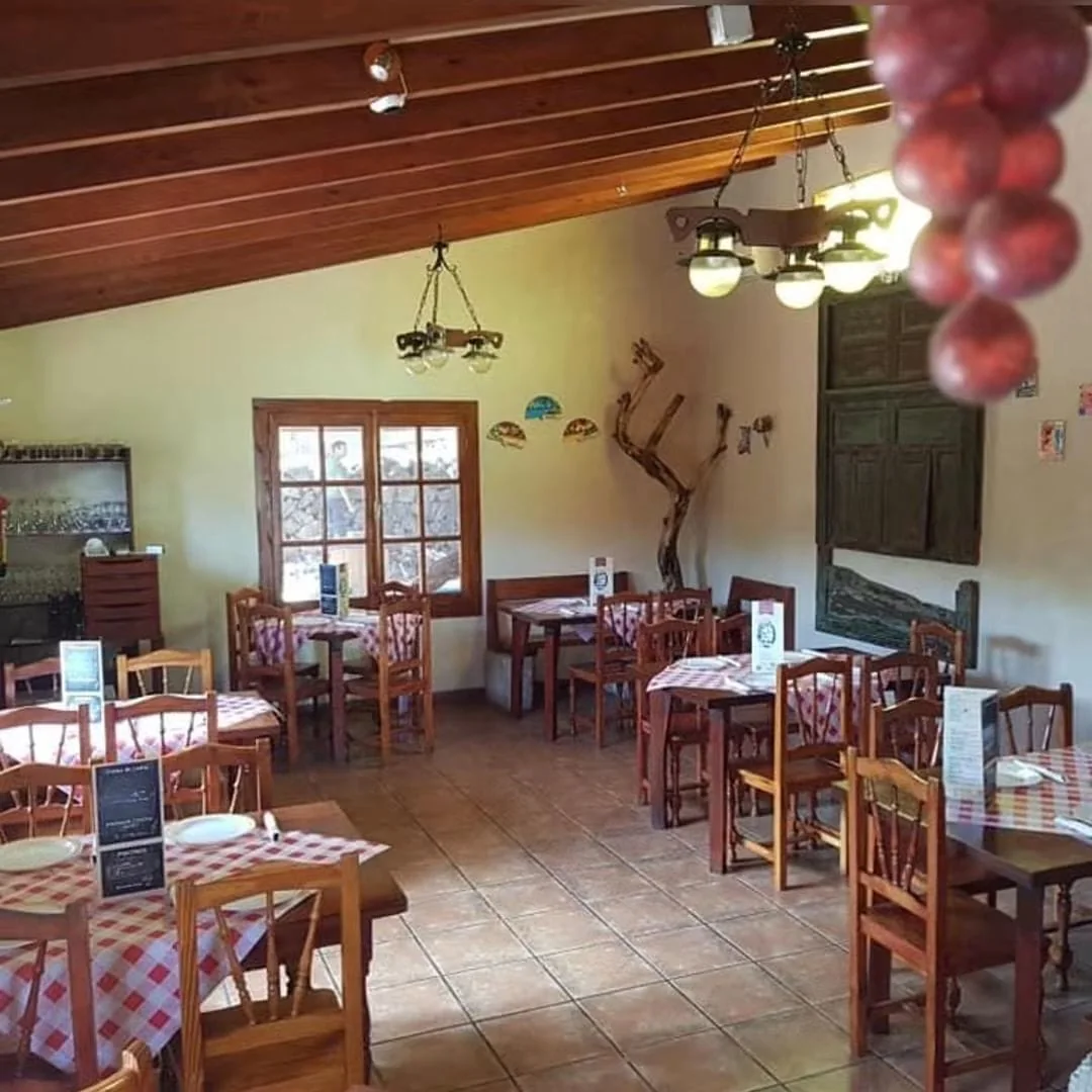 Comedor de La Carreta del Carretón, con las mesas vestidas de cuadros y el techo de madera